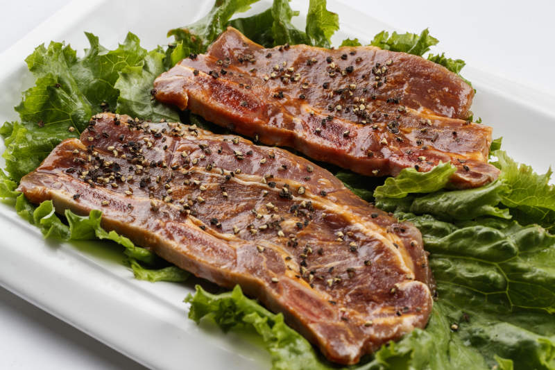 長(zhǎng)方形白瓷盤(pán)裝的黑胡椒腌制牛排肉