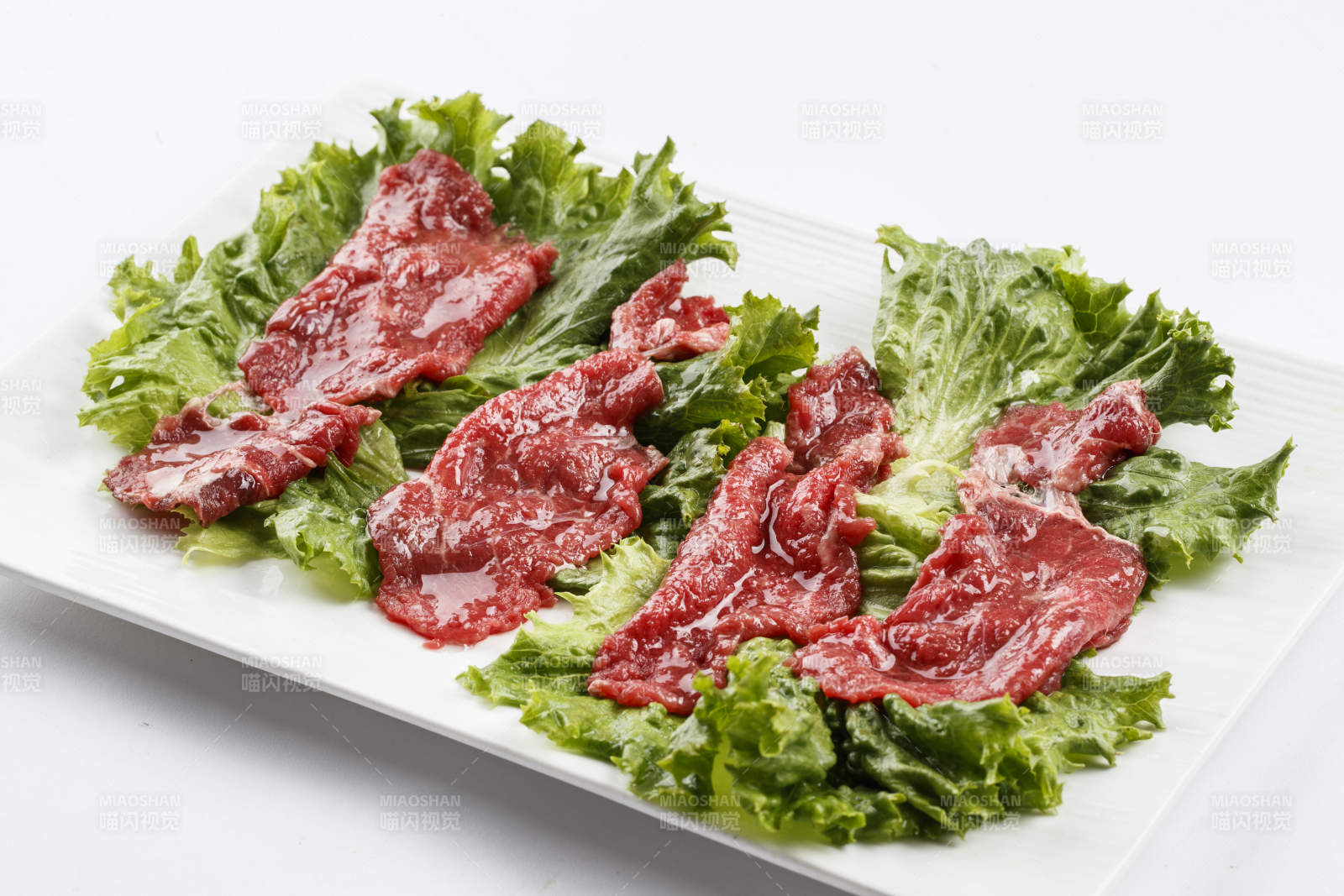 长方形白瓷盘装的鲜切牛里脊肉