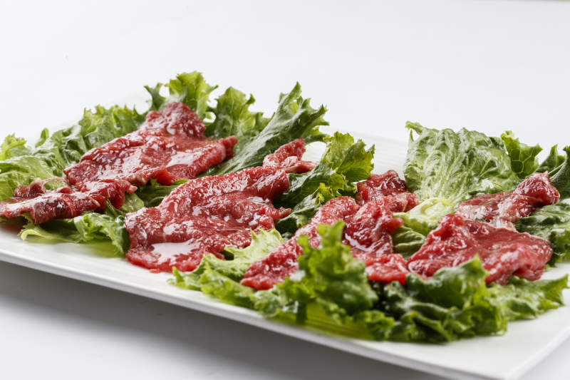 长方形白瓷盘装的鲜切牛里脊肉