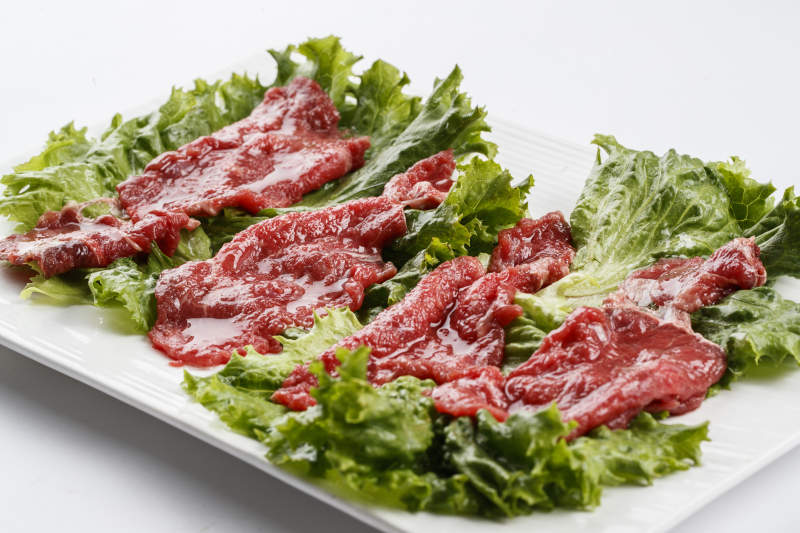 长方形白瓷盘装的鲜切牛里脊肉