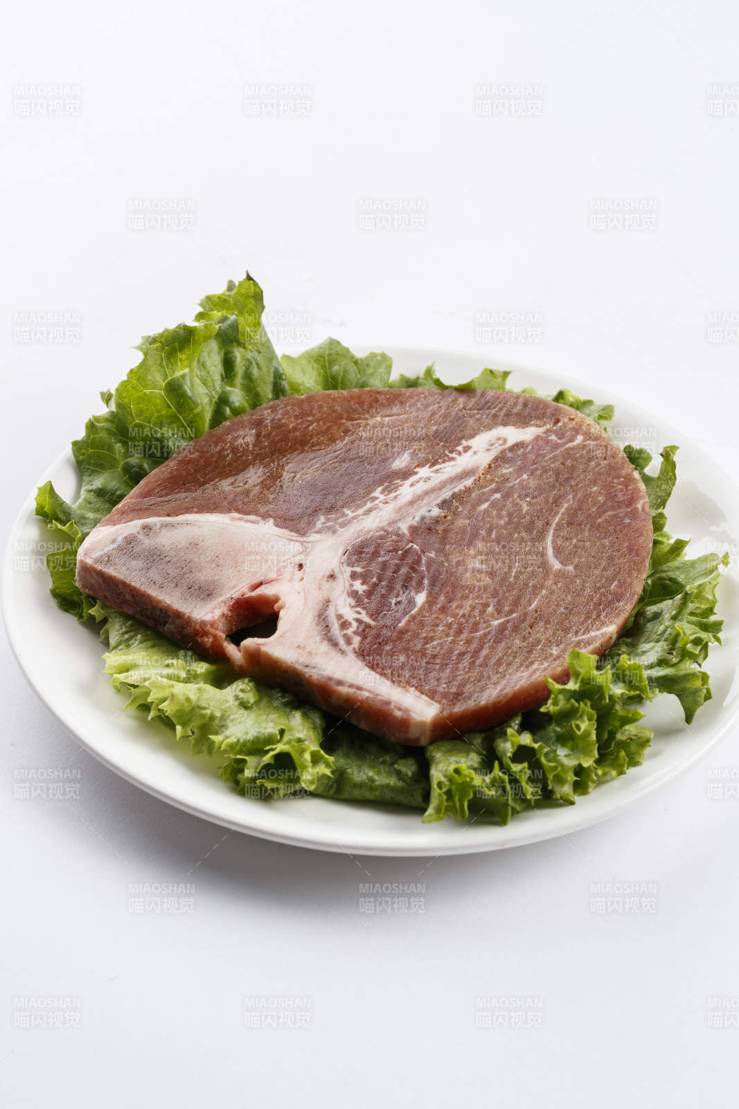 圆形白色瓷盘装的T骨牛排