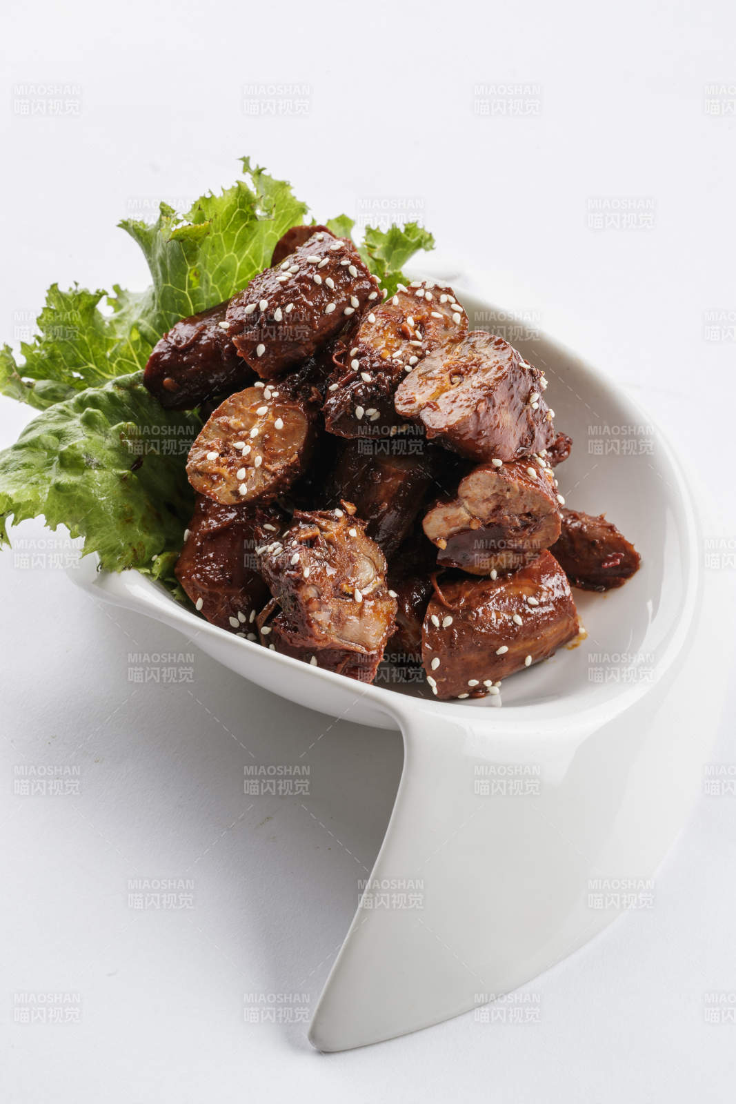 勺型白瓷盘装的麻辣鸭脖