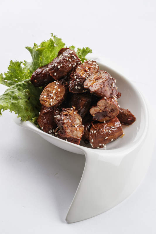 勺型白瓷盘装的麻辣鸭脖