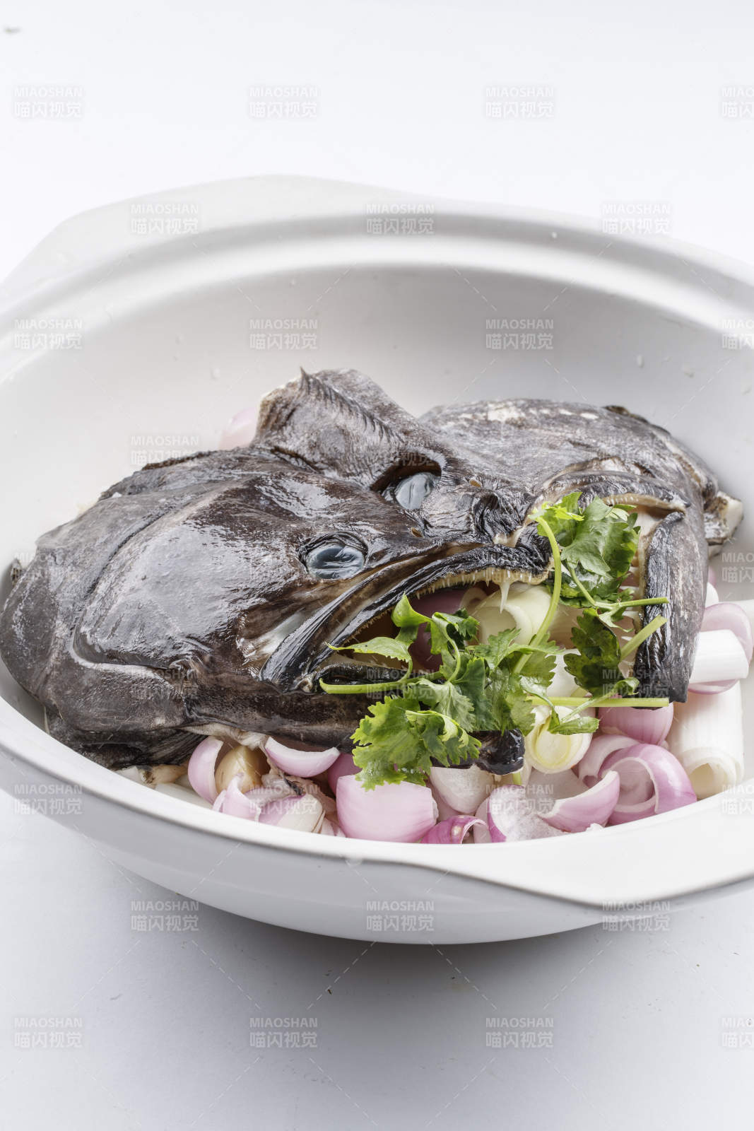 陈旧木板上的黑色砂锅装的浓汤生噘鲽鱼