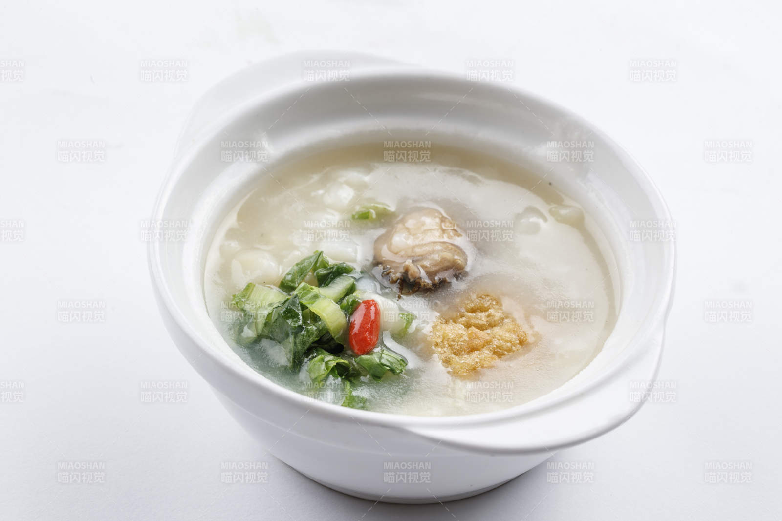 白色瓷碗裝的鮮鮑魚小白菜粥