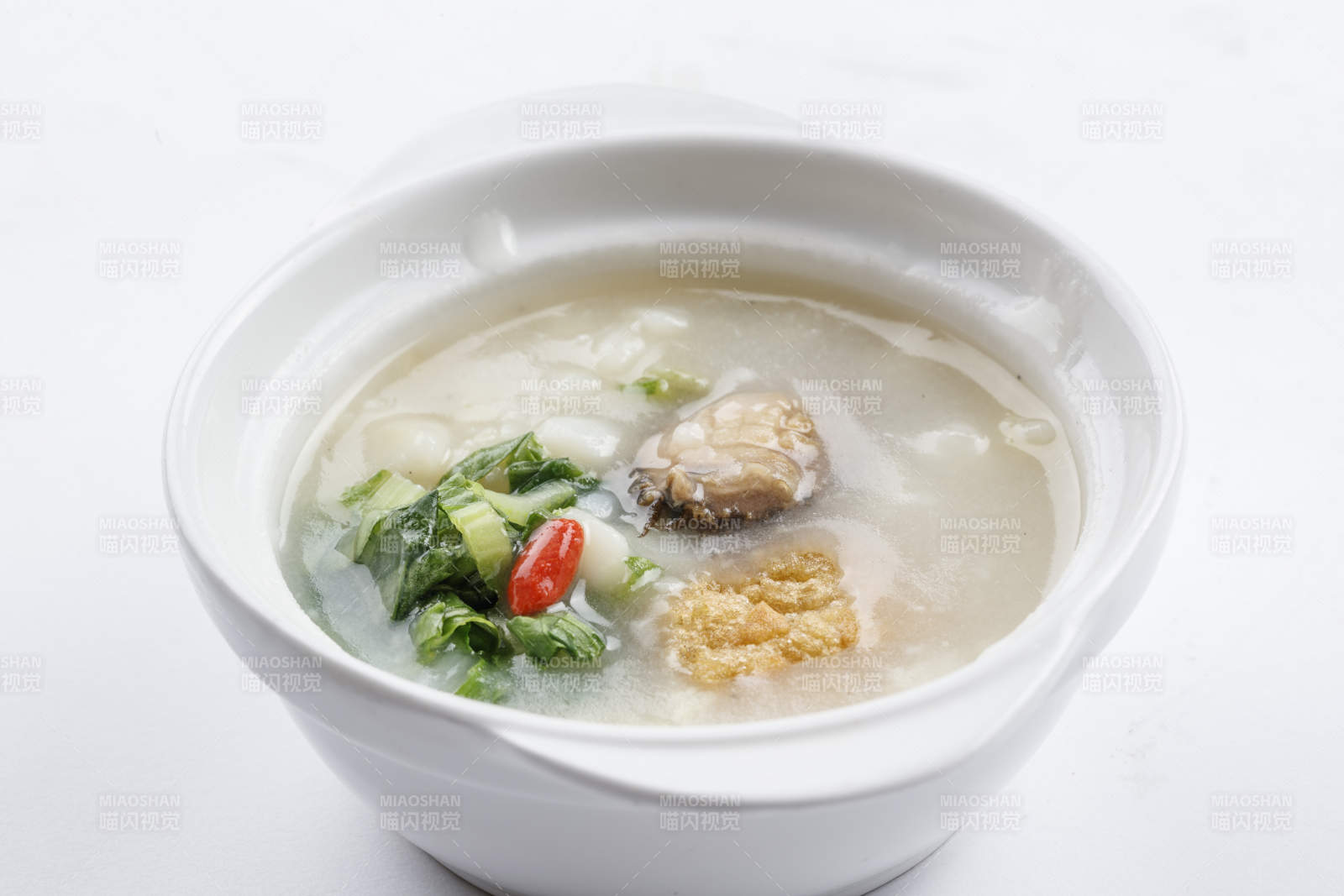 白色瓷碗裝的鮮鮑魚小白菜粥