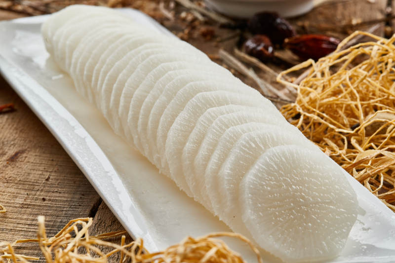 白色长瓷盘装的白萝卜片火锅涮菜