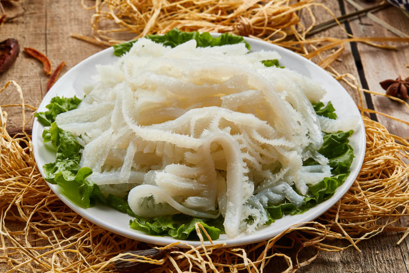 白色圆瓷盘装的金钱肚火锅涮菜