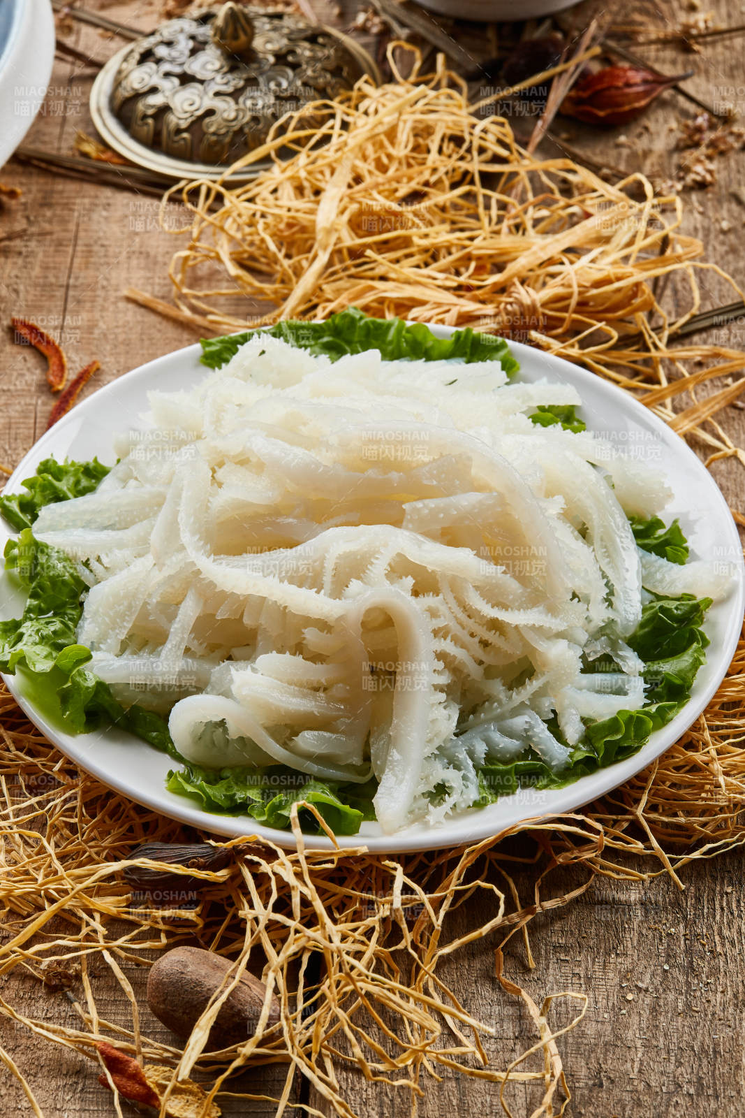 白色圆瓷盘装的金钱肚火锅涮菜