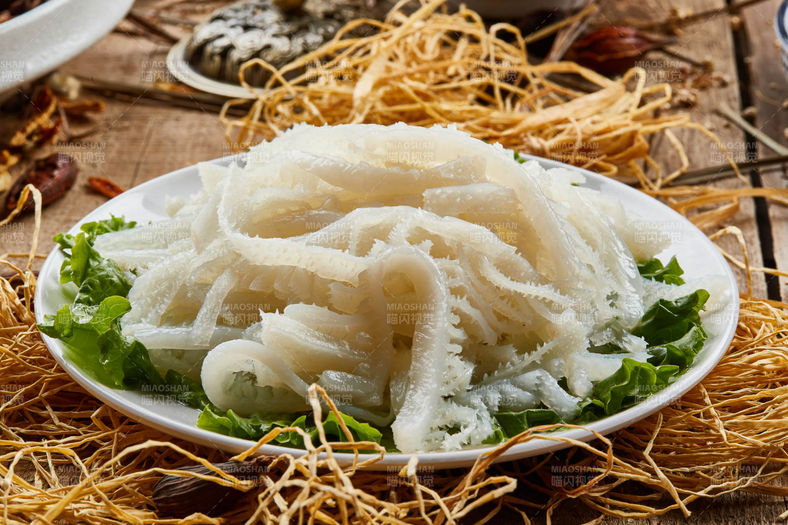 白色圆瓷盘装的金钱肚火锅涮菜