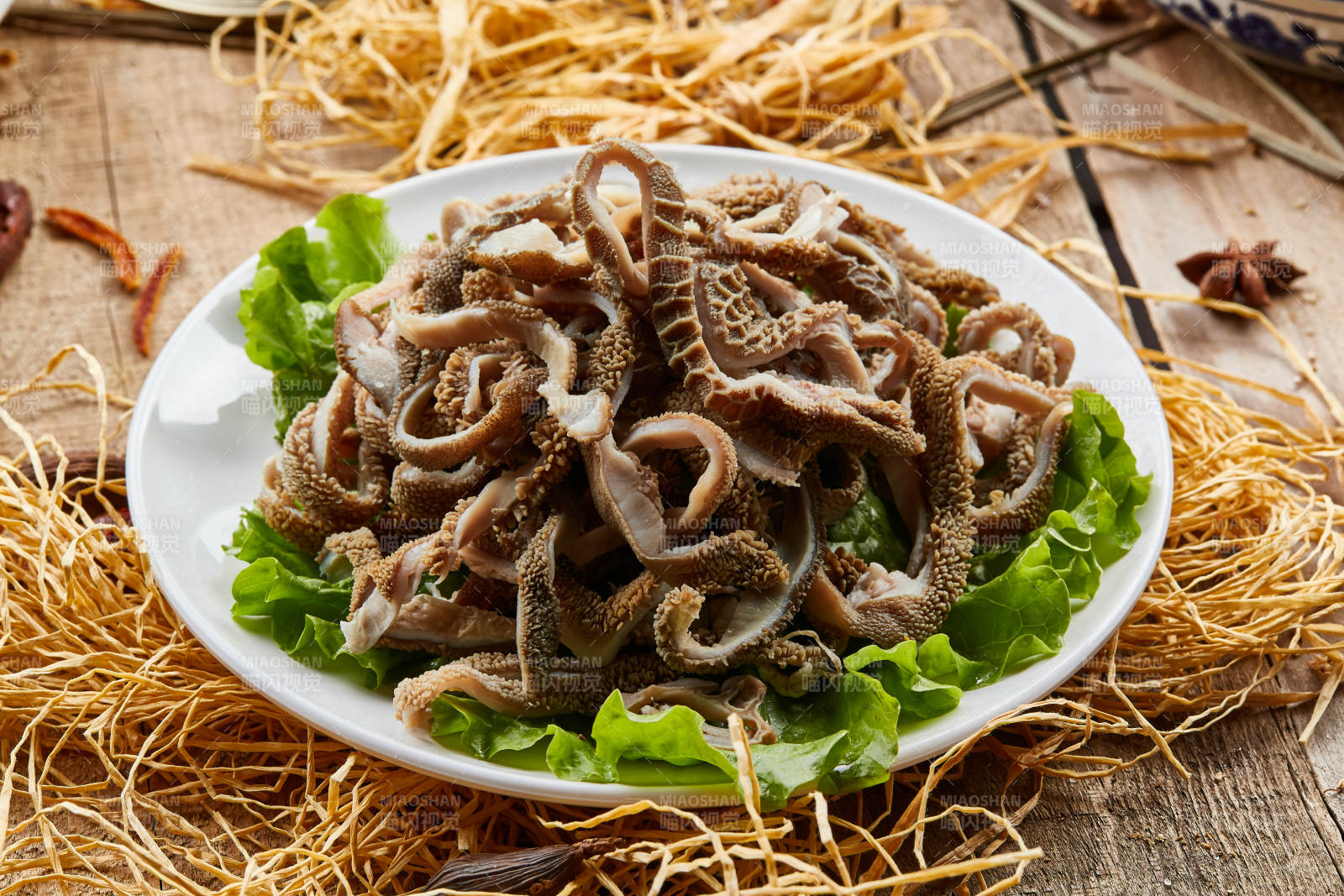 白色圓瓷盤裝的羊肚仁兒火鍋涮菜