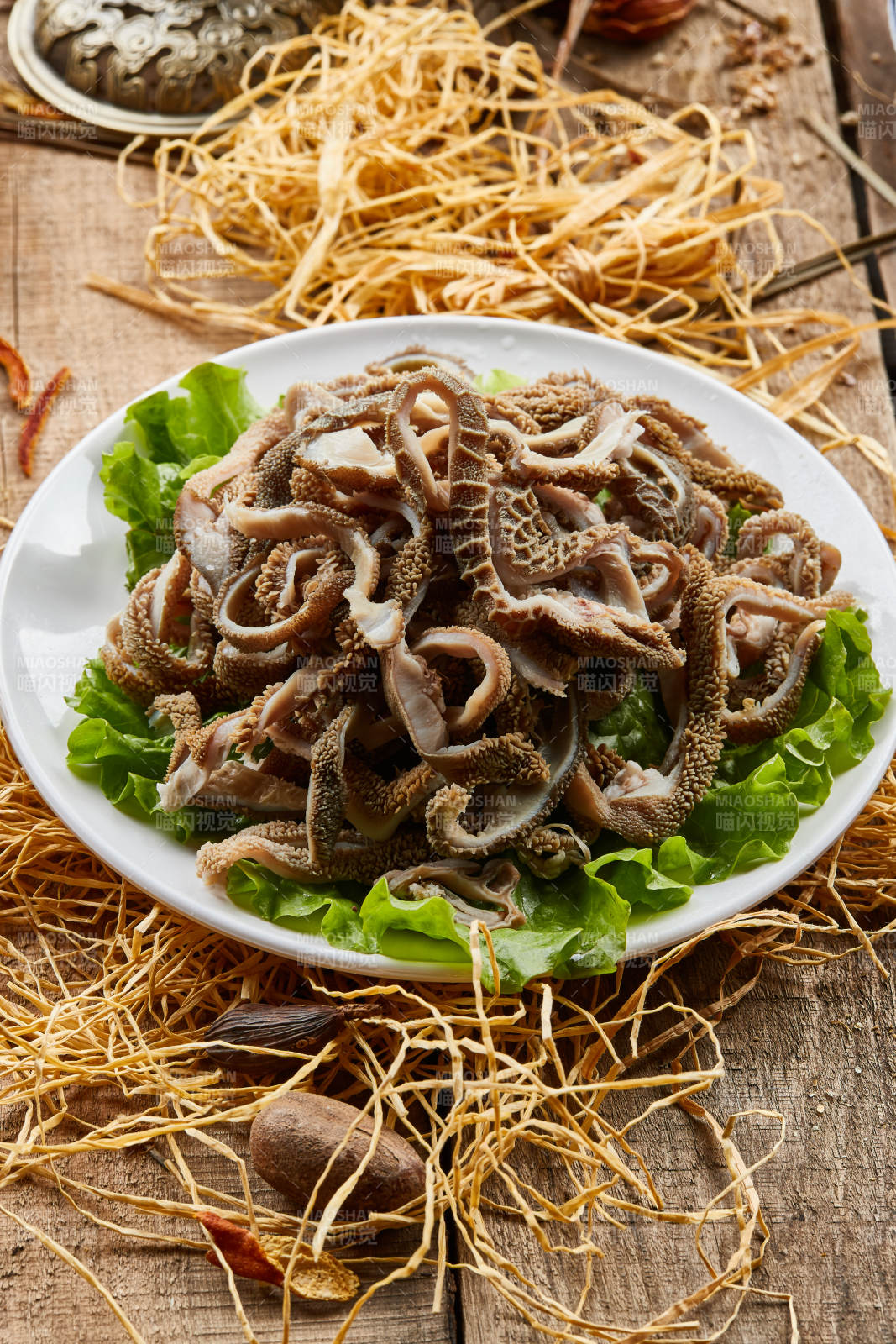 白色圓瓷盤裝的羊肚仁兒火鍋涮菜