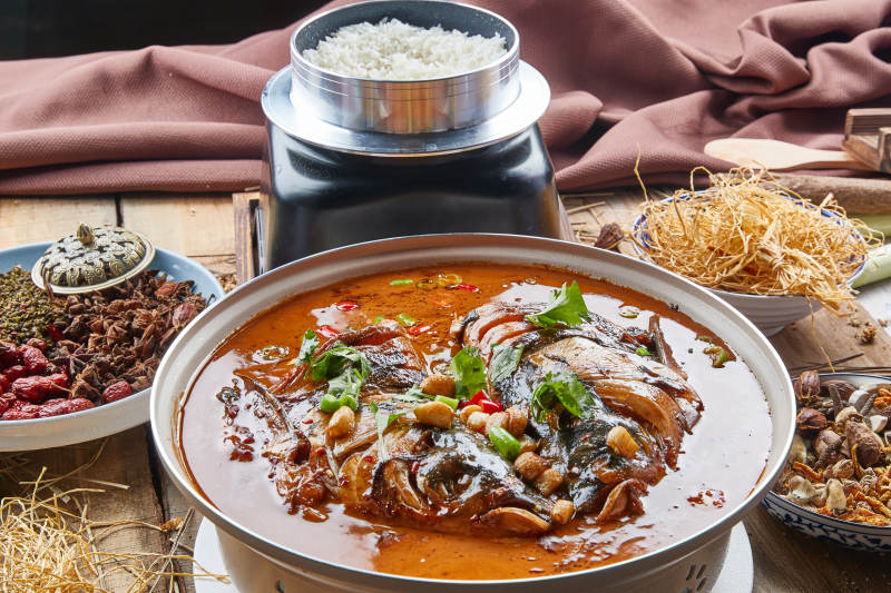 大型器皿装的家炖野生大鱼头配米饭