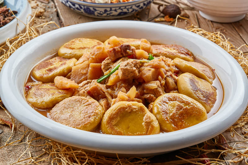 圓瓷盤裝的農家燉菜配拿糕