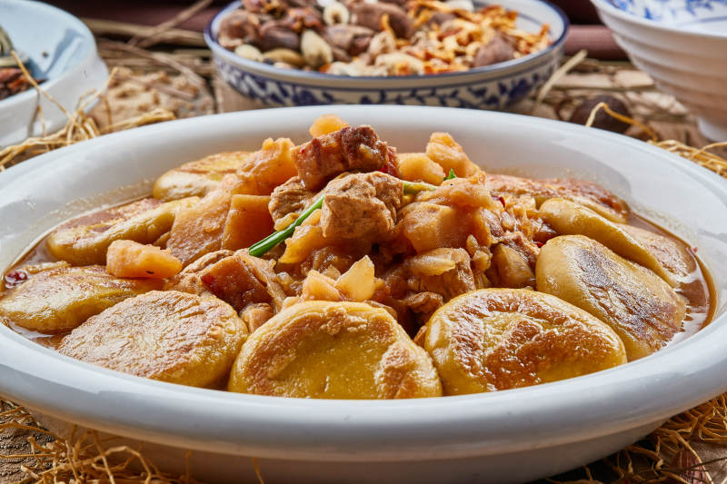 圓瓷盤裝的農家燉菜配拿糕