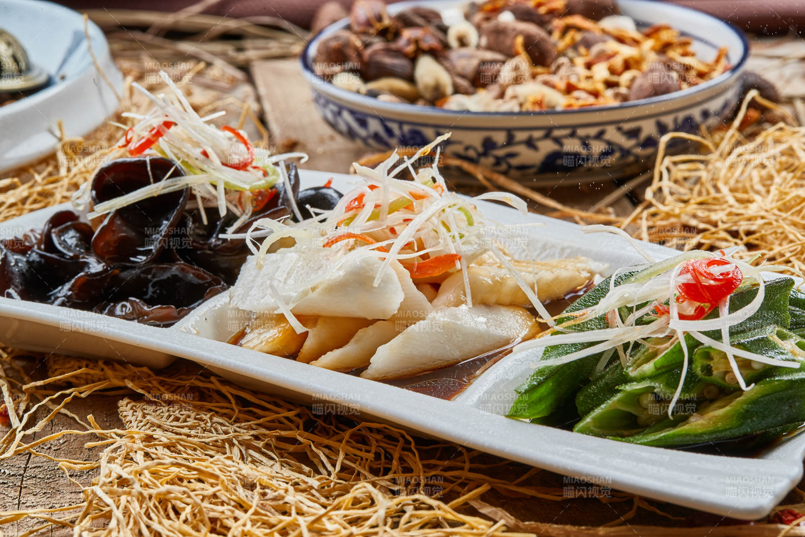 三格瓷盘装的酸辣小菜木耳山药秋葵