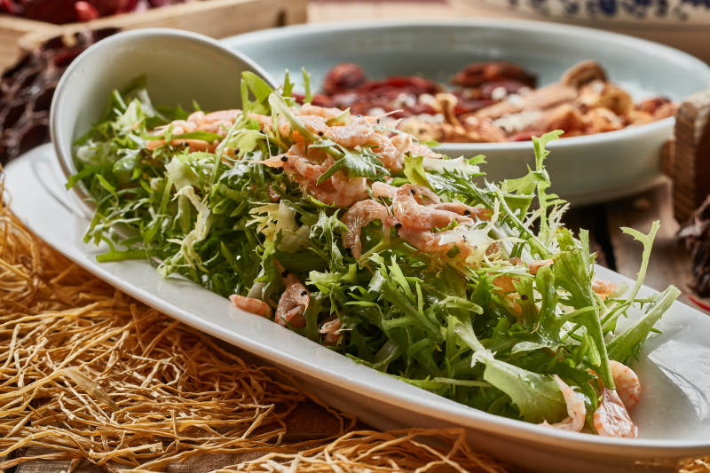 青色瓷餐具装的苦菊拌河虾