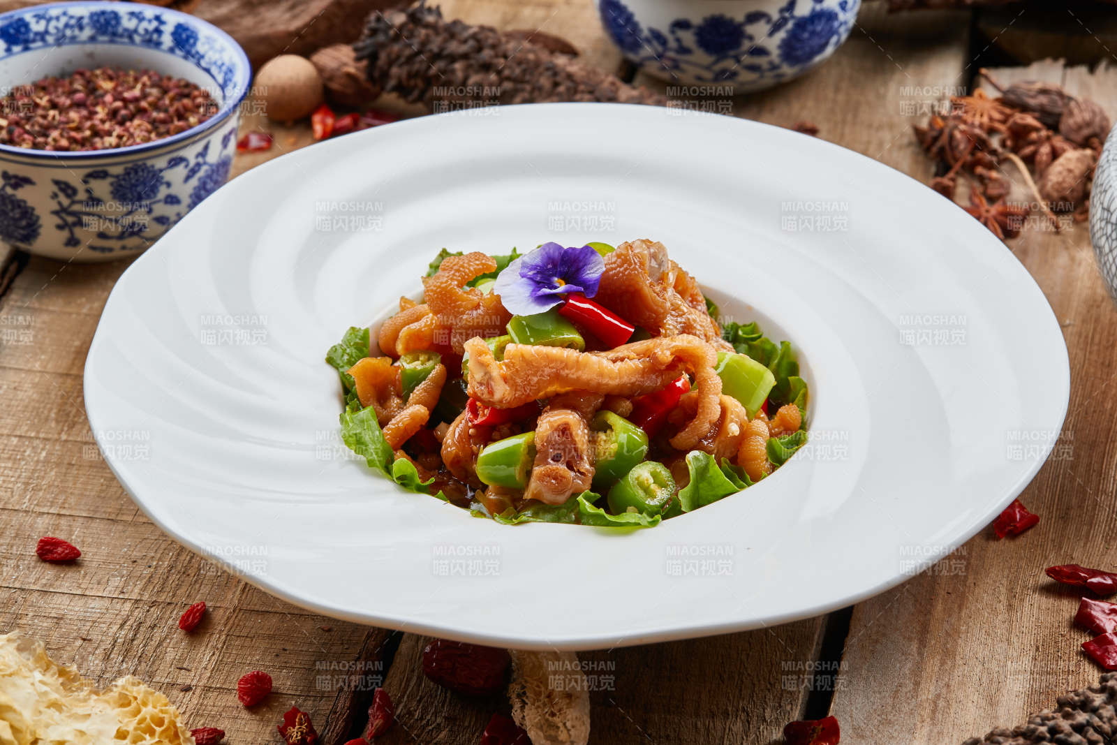 白色瓷盘装的红油酸辣脱骨凤爪-摄影图