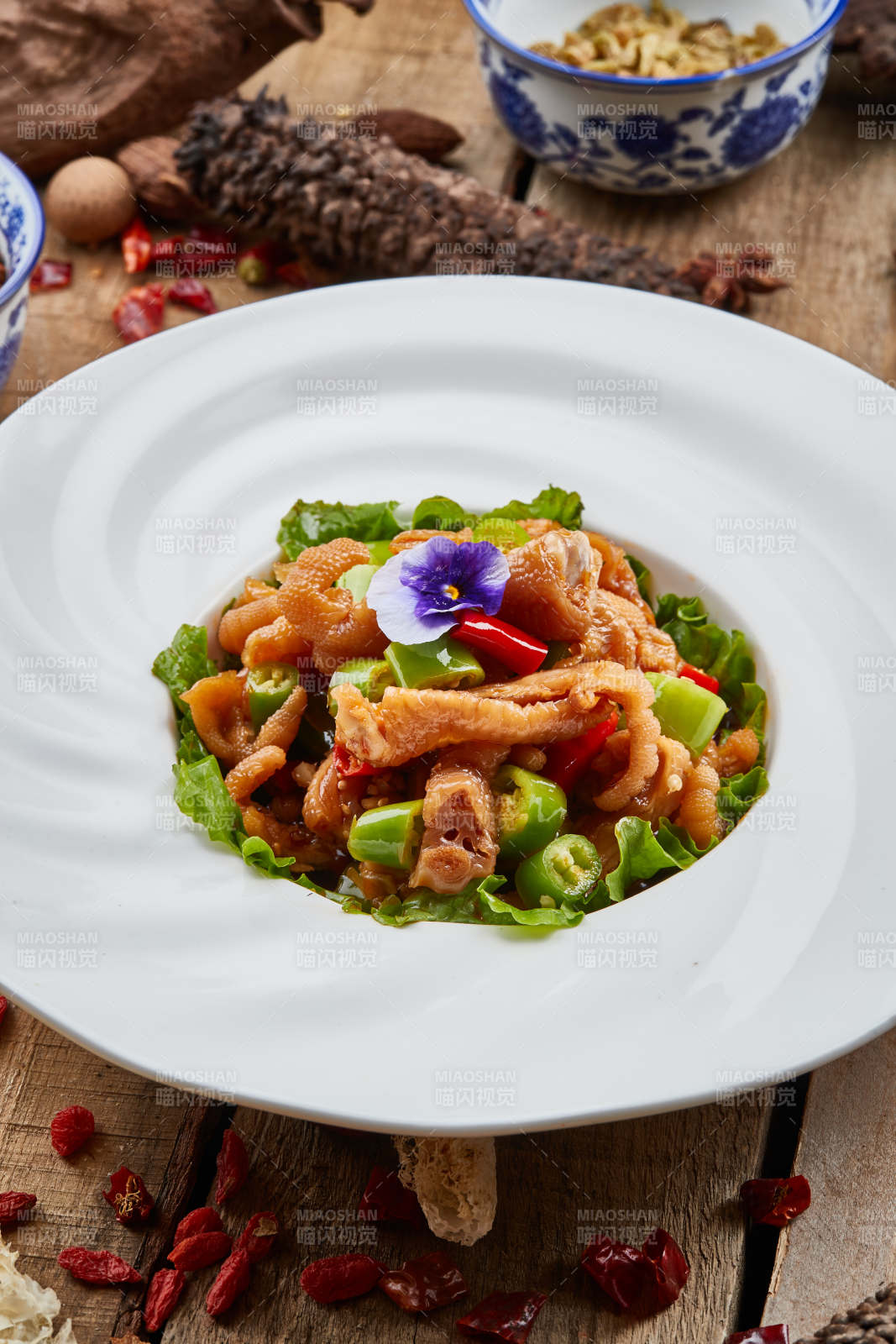 白色瓷盘装的红油酸辣脱骨凤爪-摄影图