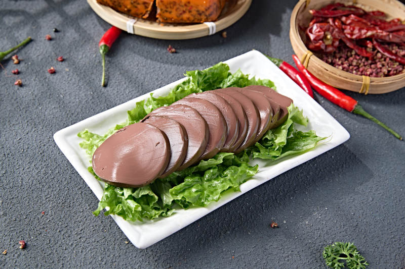 白色瓷盘装的火锅食材鸭血切片