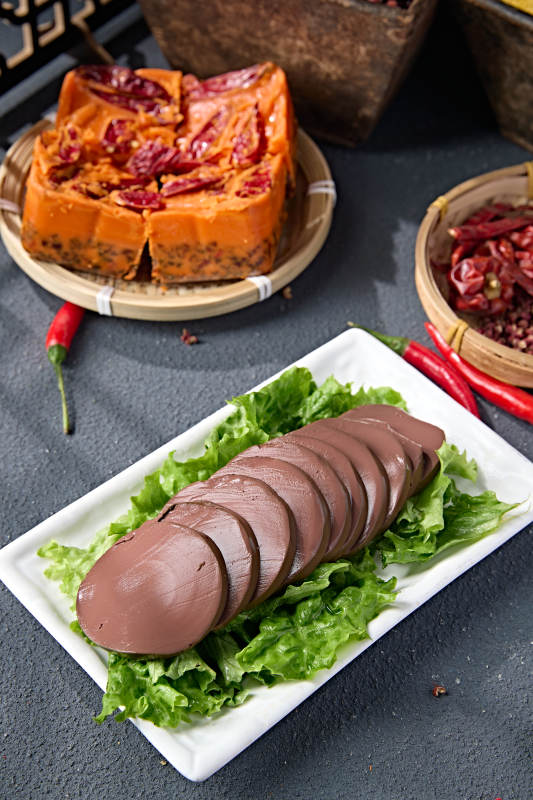 白色瓷盘装的火锅食材鸭血切片