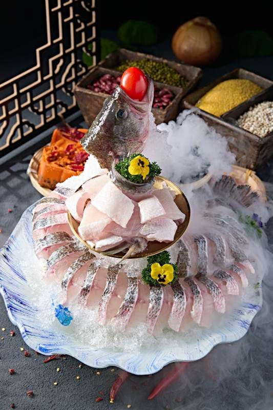 布满碎冰的青色瓷盘装的海鲈鱼刺身生鱼片