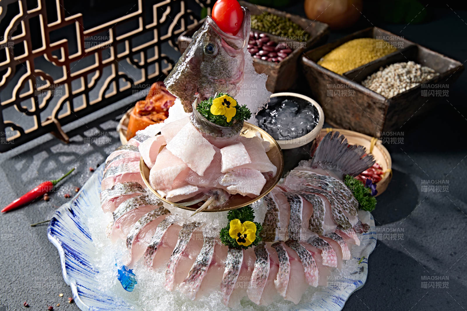 布满碎冰的青色瓷盘装的海鲈鱼刺身生鱼片