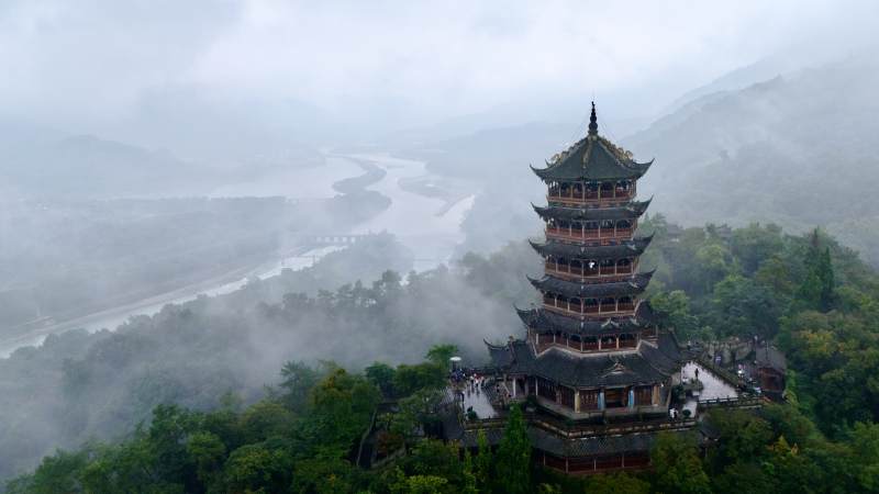 雾中古塔山河景