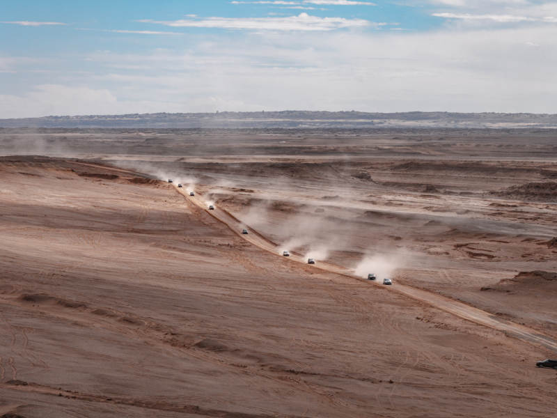 广袤荒漠中车队在火星无人区疾驰沙尘飞扬