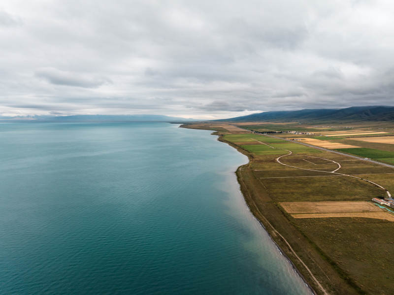海岸线与农田交错自然风光航拍山脉云层地理
