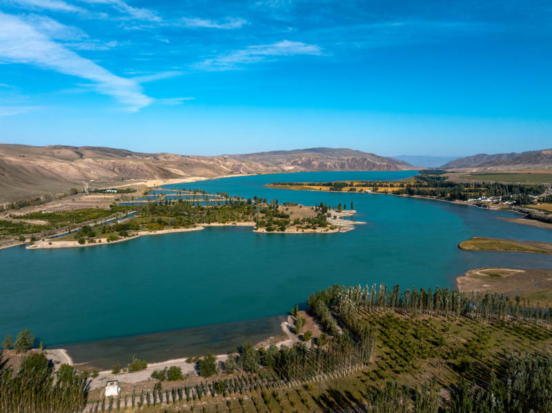 蜿蜒河流如丝带穿行伊犁绿洲农田间和谐美景