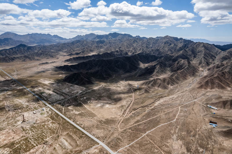 西北苍凉荒漠戈壁沙漠山脉公路蓝天白云航拍