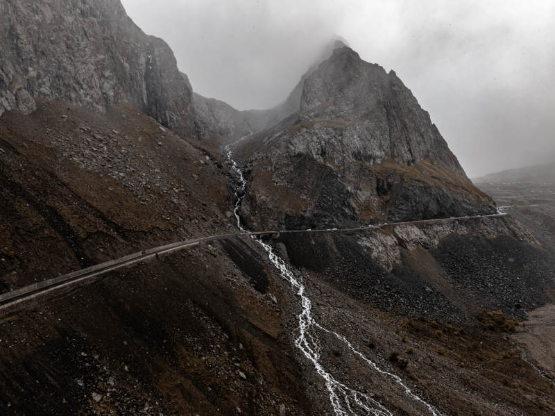 雨雾群山瀑布与蜿蜒公路交织的原始自然风光