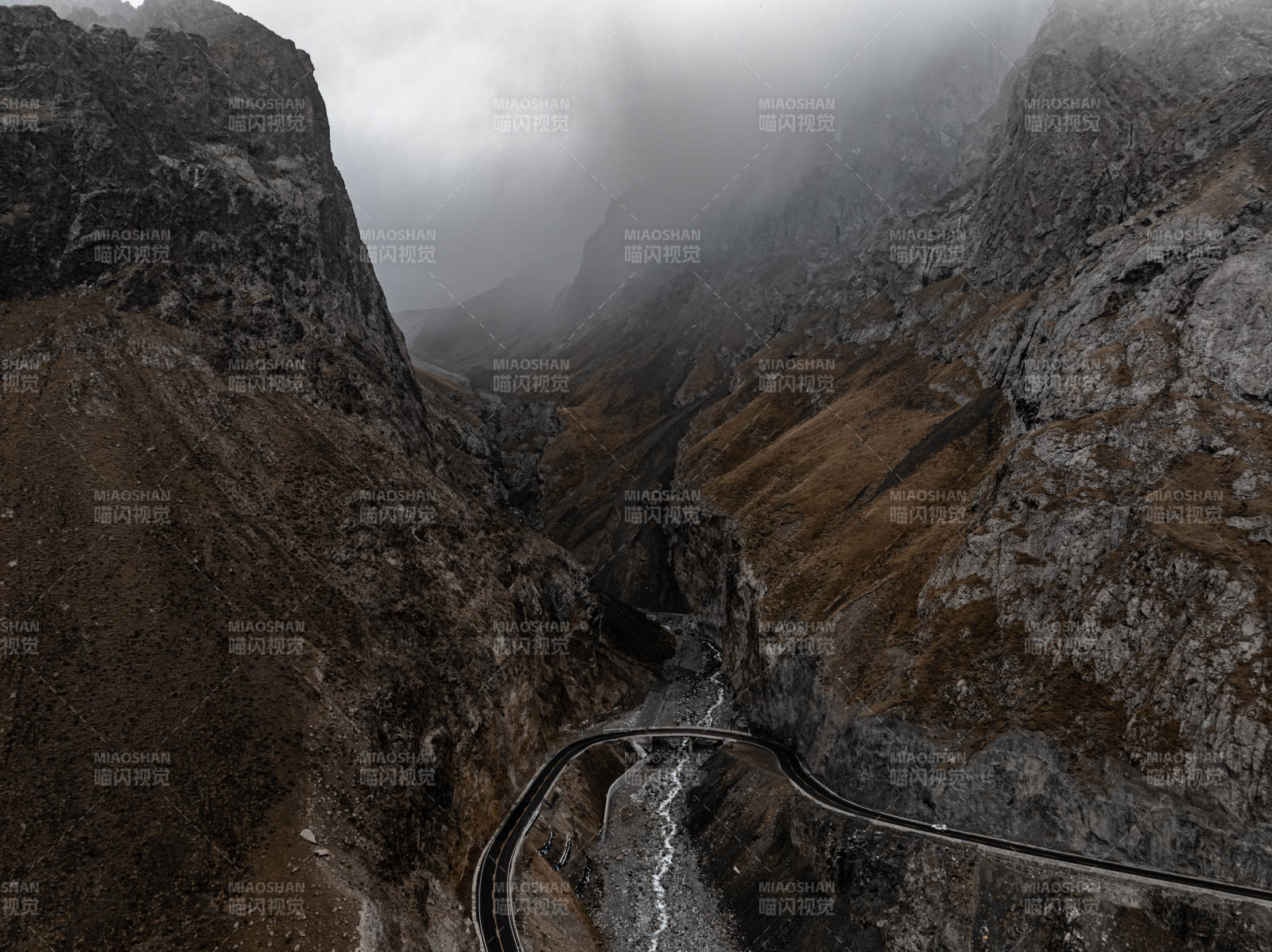 云雾缭绕山谷蜿蜒公路与岩石山峰的独库公路