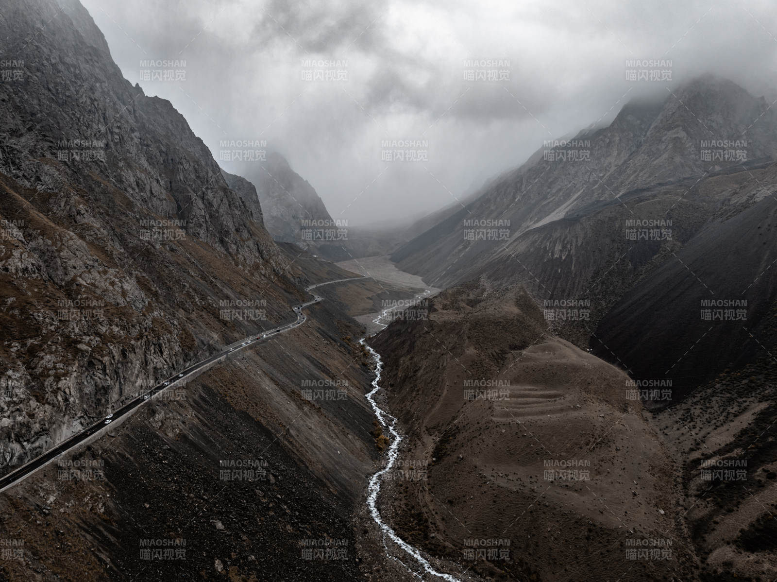 云雾山谷中蜿蜒公路与溪流相映的静谧自然景