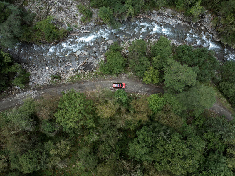 自驾汽车在山林溪流边穿越原始森林越野探险