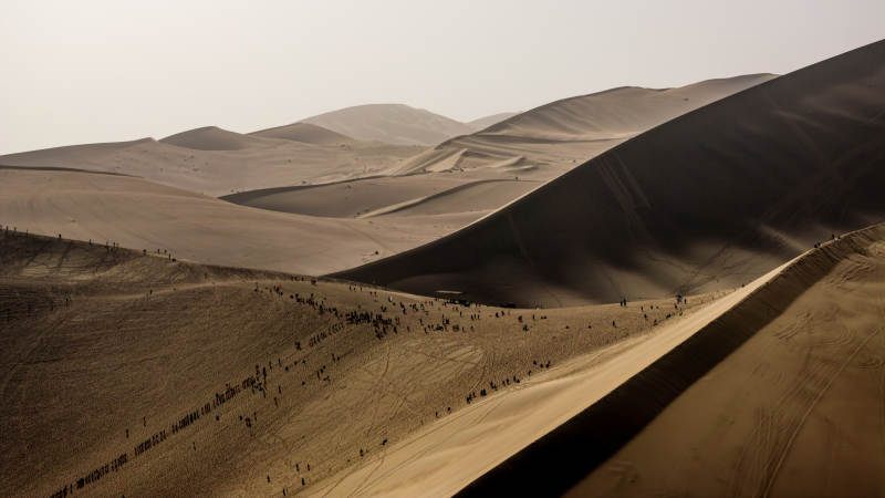 壮阔沙漠光影线条沙丘景观鸣沙山游客人群