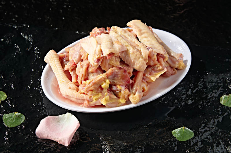 摆放在白色背景上分切好的生鲜鸡肉