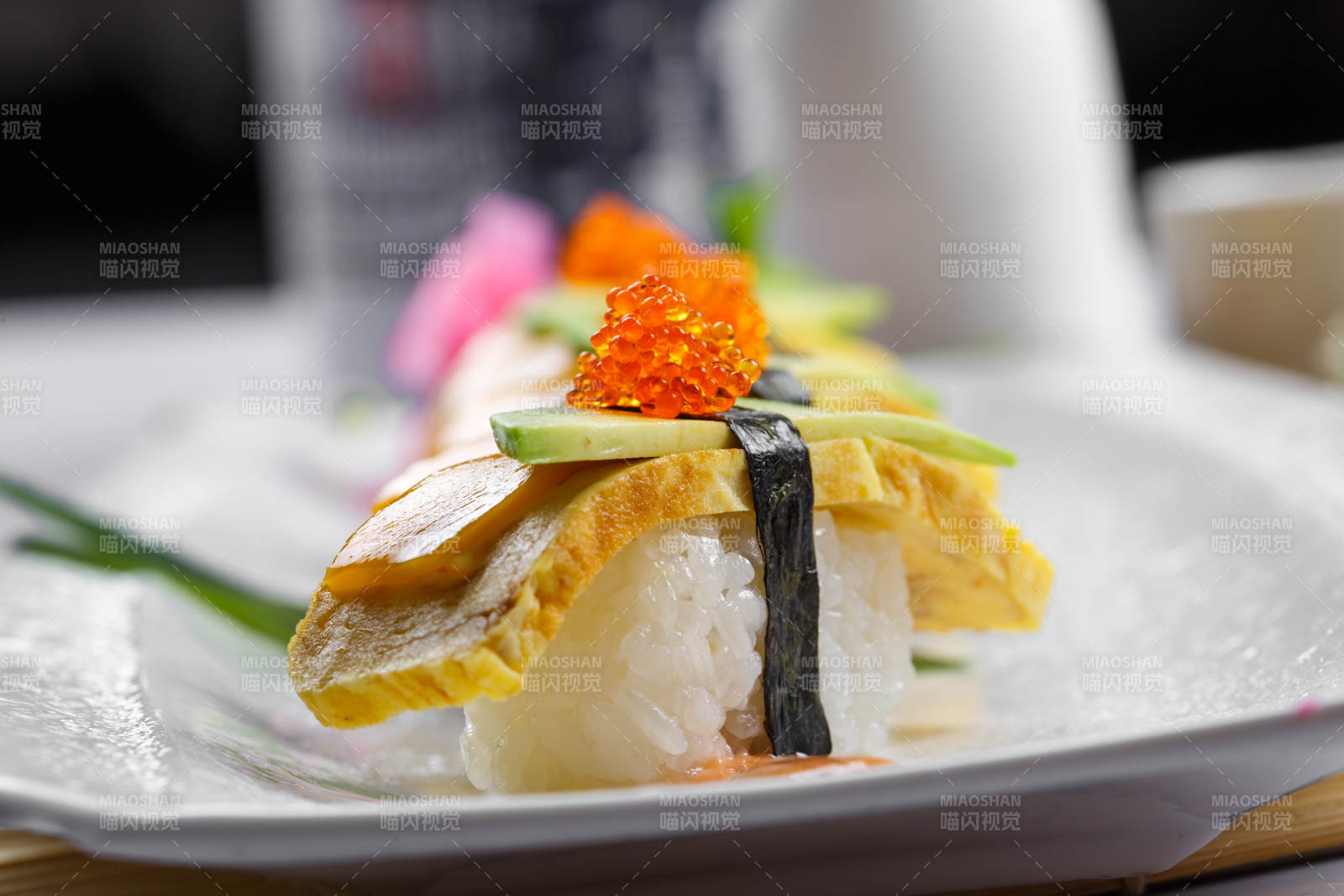 烧蛋蟹子芒果手握寿司摆放在寿司帘上