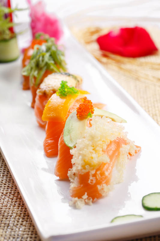 什锦三文鱼手握寿司摆放在草垫上