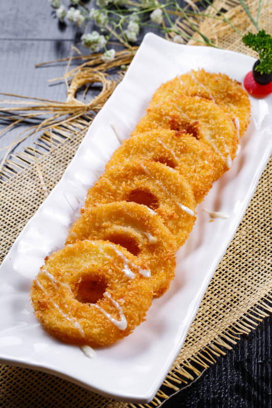 白色瓷盘装的的油炸菠萝派