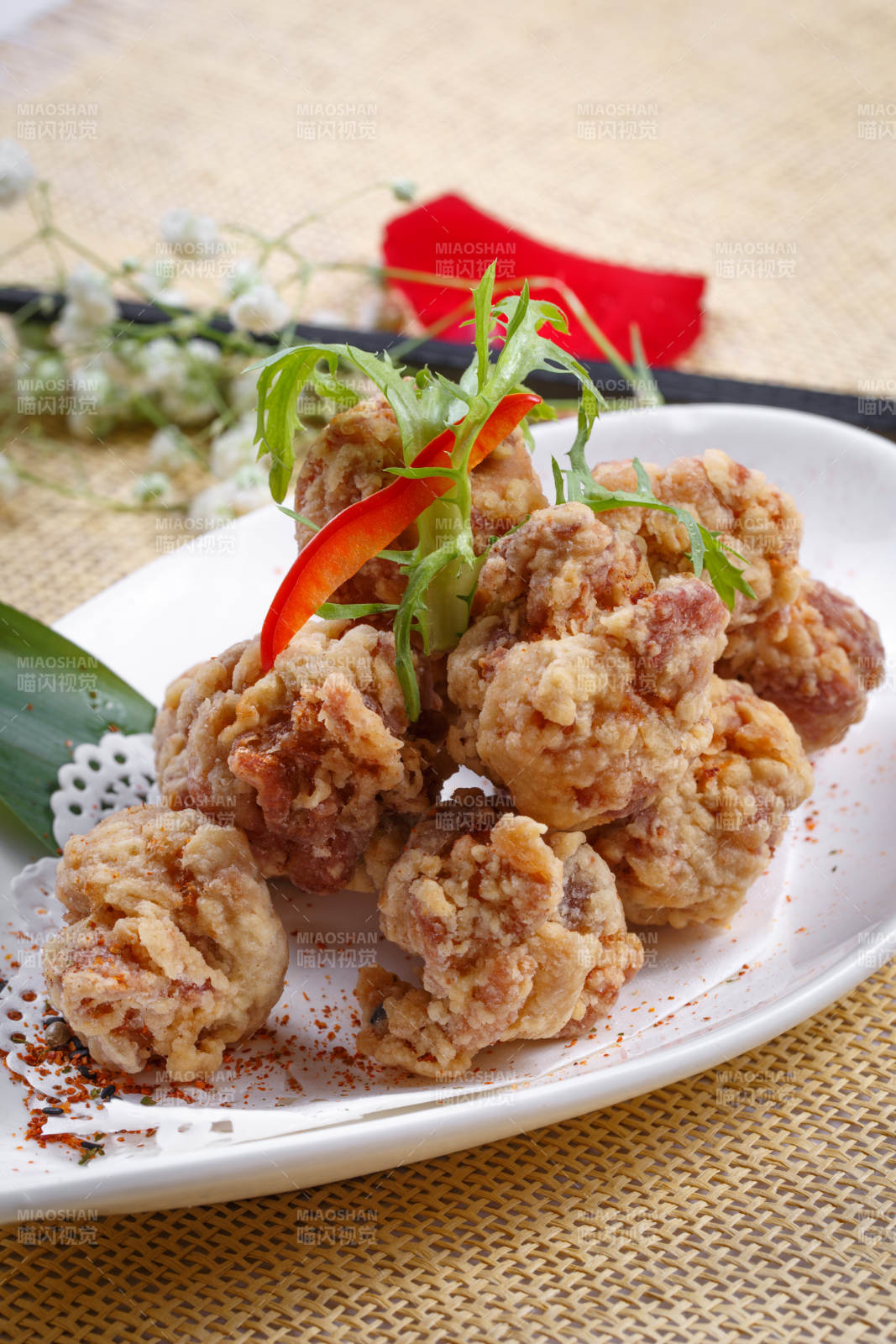 鹅颈瓷盘装的炸鸡块摆放在草垫上
