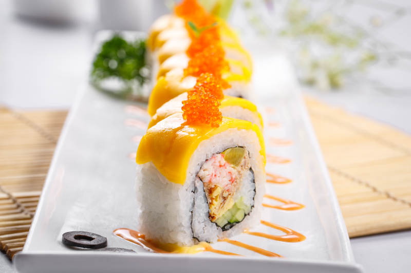 黄金甲蟹子寿司卷摆放在寿司帘上