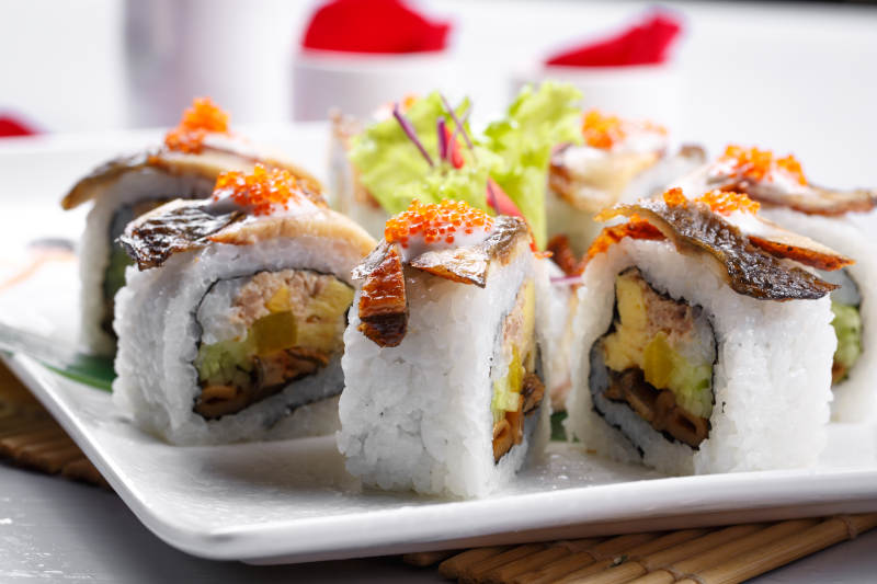 什锦鳗鱼手卷寿司摆放在寿司帘上