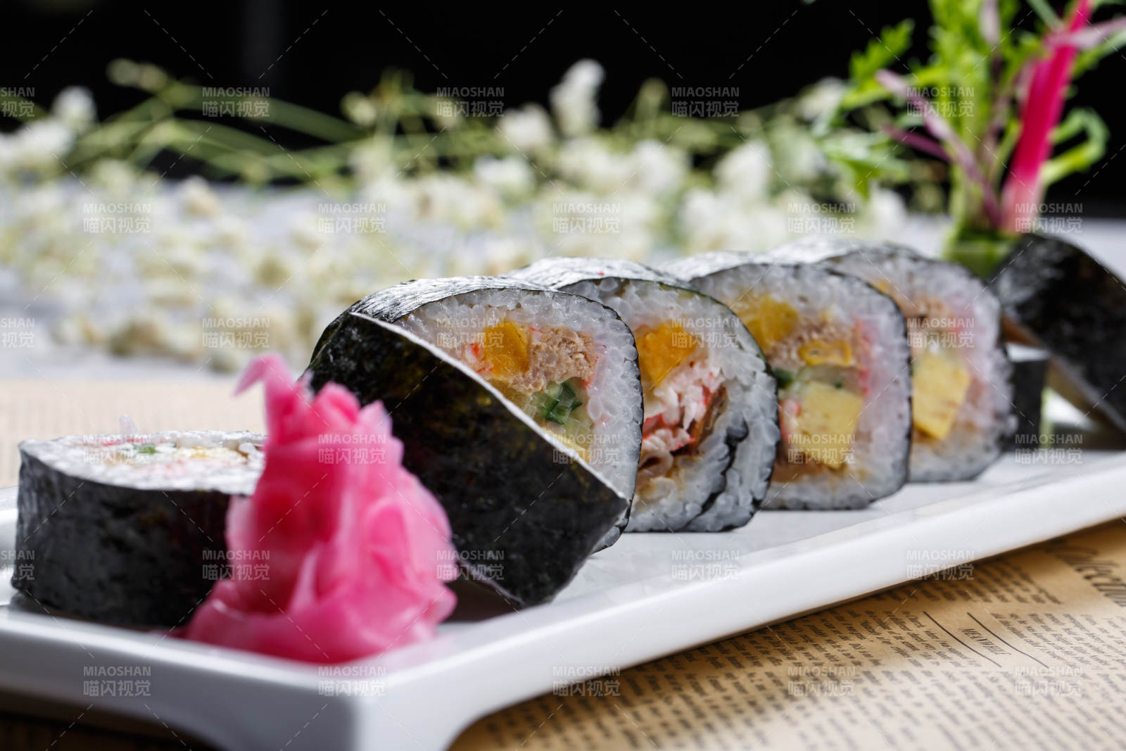 什錦太手卷壽司擺放在英文包裝紙上