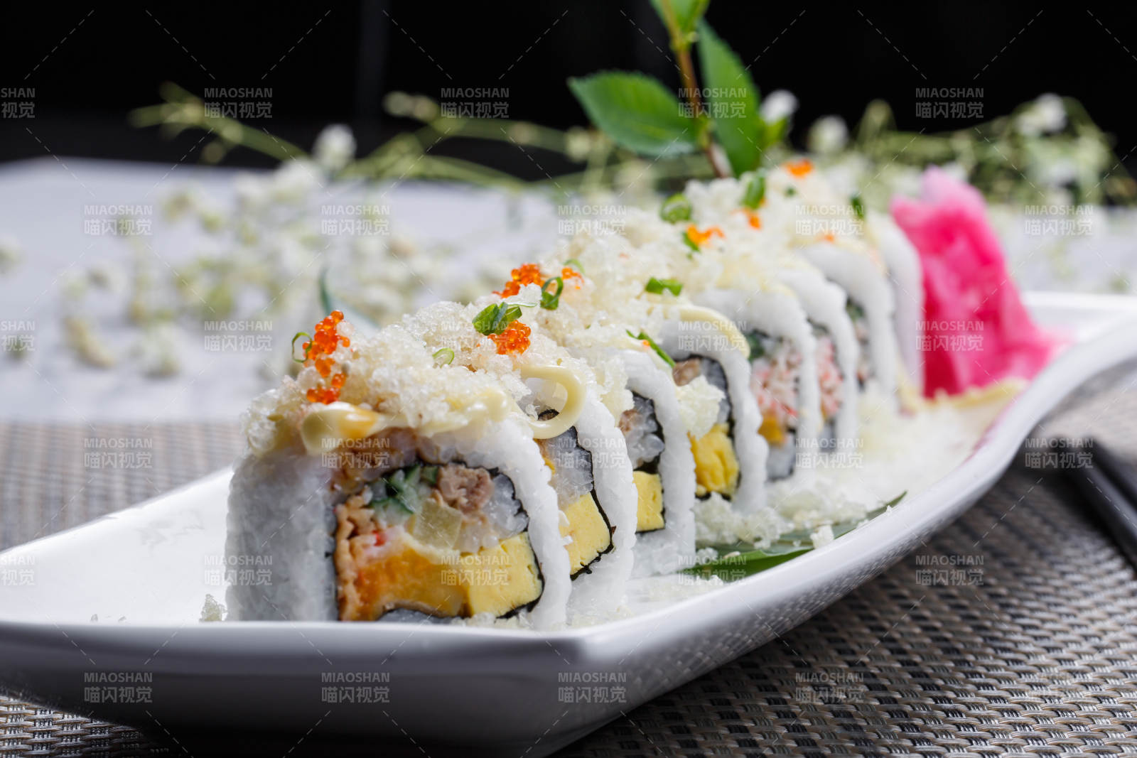 長方形瓷盤裝的脆脆卷壽司擺放在餐墊上