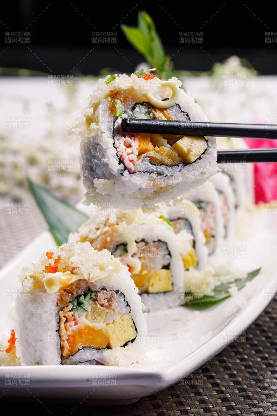 長方形瓷盤裝的脆脆卷壽司擺放在餐墊上