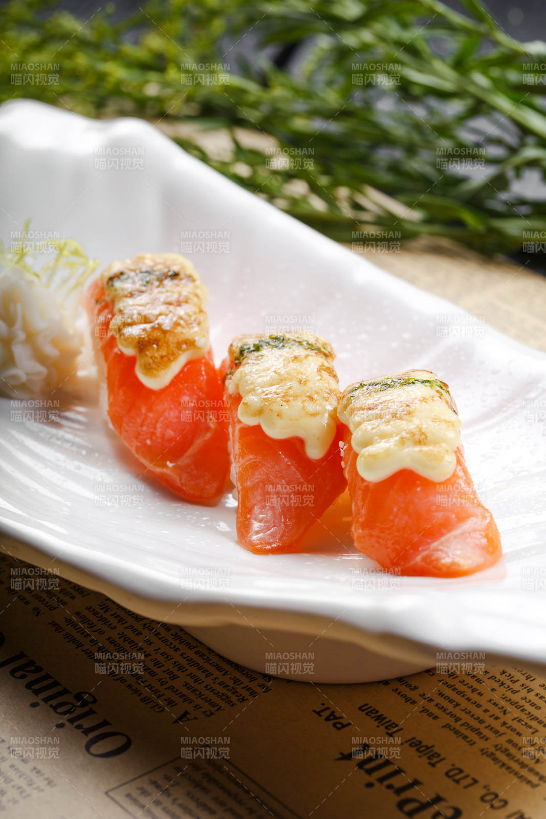 芝士焗三文鱼手握寿司摆放在英文包装纸上