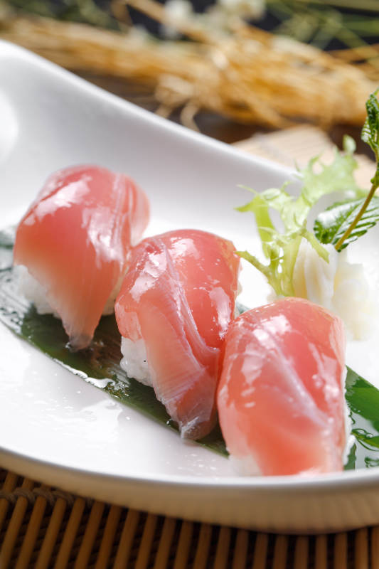 金枪鱼手握寿司摆放在寿司帘上