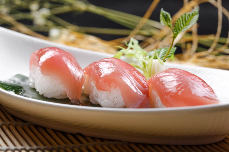 金枪鱼手握寿司摆放在寿司帘上